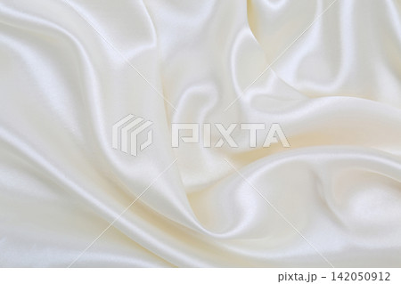 Smooth elegant white silk or satin luxury cloth texture as wedding background. Luxurious background design Smooth elegant white silk or satin luxury cloth texture as wedding background. Luxurious background design 142050912