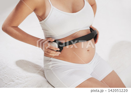 Pregnant, stomach and headphones for music, baby and woman on bed, relax and peace in home and apartment. House, mom and person with sound, growth and development of child, soothing and positive 142051220