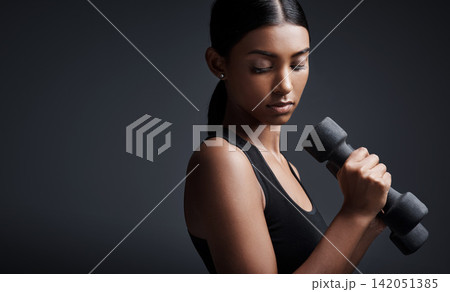 Indian woman, dumbbells and weightlifting in studio for training on black background, lose weight or mockup. Female person, exercise and gym fitness workout or bicep muscle, resilience or challenge Indian woman, dumbbells and weightlifting in studio for training on black background, lose weight or mockup. Female person, exercise and gym fitness workout or bicep muscle, resilience or challenge 142051385