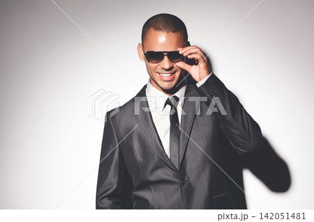 Man, suit and sunglasses in studio with smile for confidence, fashion and job as spy by white background. Person, bodyguard or government agent with style for secret international mission in London Man, suit and sunglasses in studio with smile for confidence, fashion and job as spy by white background. Person, bodyguard or government agent with style for secret international mission in London 142051481