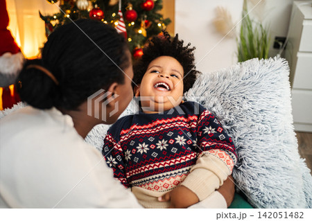 Mother and child sharing joyful Christmas holiday laughter 142051482
