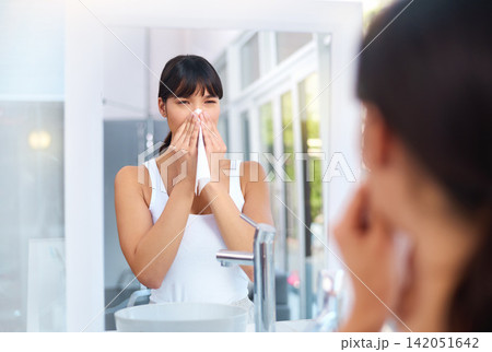 Asian, woman and allergies in bathroom for healthcare, virus and illness in house for weather change. Sick female person, cough and tissue for sneezing, flu and unhealthy in mirror reflection. Asian, woman and allergies in bathroom for healthcare, virus and illness in house for weather change. Sick female person, cough and tissue for sneezing, flu and unhealthy in mirror reflection. 142051642