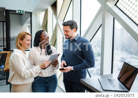 Diverse startup team collaborating using digital tablet and technology Diverse startup team collaborating using digital tablet and technology 142052075