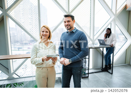 Three business people working on tasks in a contemporary office setting 142052076