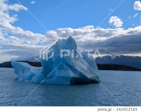 Blue Iceberg Beneath Dramatic Clouds in Canal Upsala Blue Iceberg Beneath Dramatic Clouds in Canal Upsala 142052585