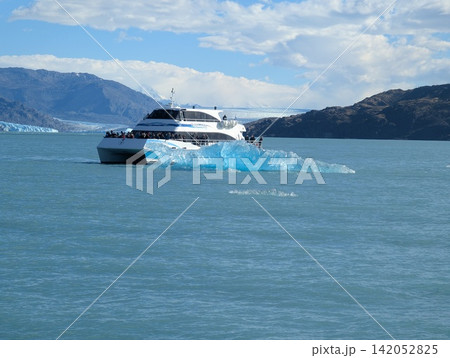 Canal Upsala, Argentina - March 11, 2026: Patagonia Infinity Catamaran Passes Blue Iceberg Canal Upsala, Argentina - March 11, 2026: Patagonia Infinity Catamaran Passes Blue Iceberg 142052825