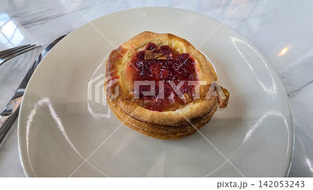 Golden flaky danish pastry jam tart puff served on a white plate with a fork on a marble table, ideal for breakfast, brunch, or dessert photography. Warm, homemade, sweet and appetizing bakery Golden flaky danish pastry jam tart puff served on a white plate with a fork on a marble table, ideal for breakfast, brunch, or dessert photography. Warm, homemade, sweet and appetizing bakery 142053243