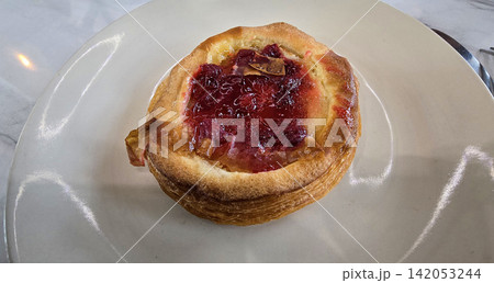 Golden flaky danish pastry jam tart puff served on a white plate with a fork on a marble table, ideal for breakfast, brunch, or dessert photography. Warm, homemade, sweet and appetizing bakery Golden flaky danish pastry jam tart puff served on a white plate with a fork on a marble table, ideal for breakfast, brunch, or dessert photography. Warm, homemade, sweet and appetizing bakery 142053244
