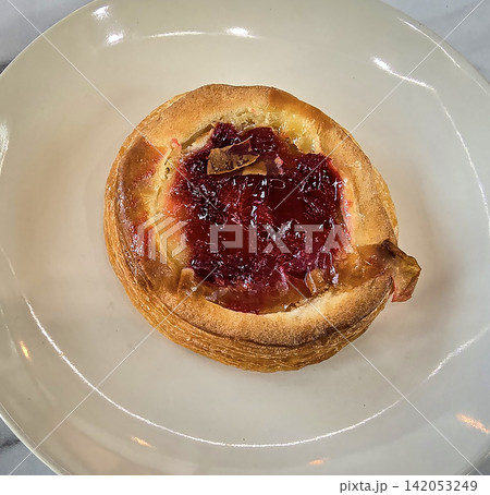 Golden flaky danish pastry jam tart puff served on a white plate with a fork on a marble table, ideal for breakfast, brunch, or dessert photography. Warm, homemade, sweet and appetizing bakery Golden flaky danish pastry jam tart puff served on a white plate with a fork on a marble table, ideal for breakfast, brunch, or dessert photography. Warm, homemade, sweet and appetizing bakery 142053249