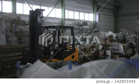 Storage Area With Stacked Materials. Busy Warehouse Showing Piled Supplies And Recycling Activity Ongoing. Media Storage Area With Stacked Materials. Busy Warehouse Showing Piled Supplies And Recycling Activity Ongoing. Media 142053343