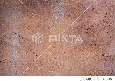 Full frame shot of an earthen wall texture of clay house structure. These walls are constructed by ramming a mixture of aggregates, including gravel, sand, silt and a small amount of clay. 142054940