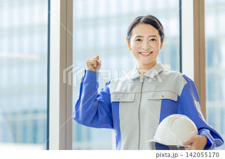 ヘルメットを持つ作業着の女性 ヘルメットを持つ作業着の女性 142055170
