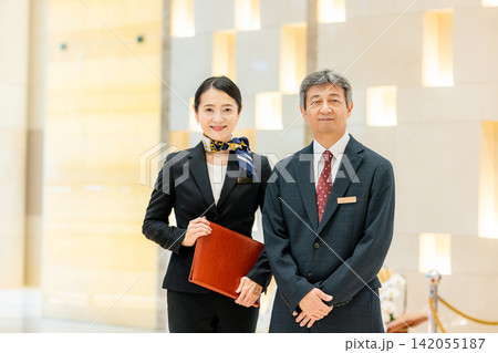 ホテルロビーに立つ支配人と女性スタッフ ホテルロビーに立つ支配人と女性スタッフ 142055187
