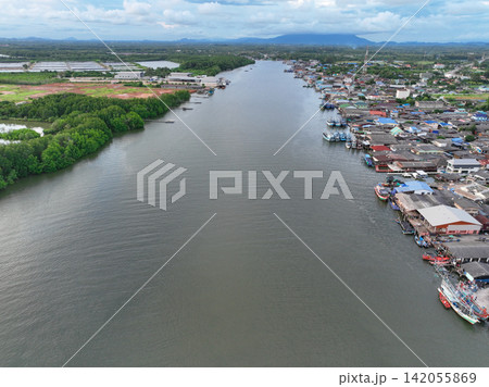 Aerial view landscape of fishing community along river, nestled within lush green mangrove forest of Pak Nam Prasae estuary in Rayong, Thailand. Ecotourism and sustainable travel. Net zero tourism. 142055869