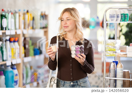 Young girl chooses and buys candles for decoration at home in store Young girl chooses and buys candles for decoration at home in store 142056020