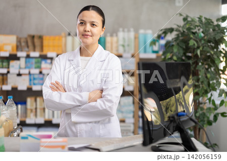 Asian pharmacist standing near the counter 142056159