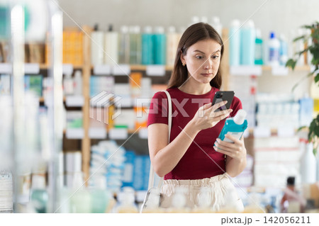 Woman scanning mouthwash barcode in pharmacy Woman scanning mouthwash barcode in pharmacy 142056211