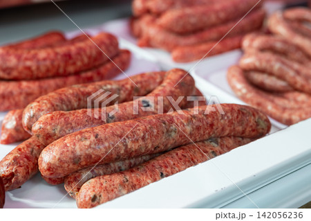 Refrigerator showcase in culinary store - various versions of butifara sausages 142056236