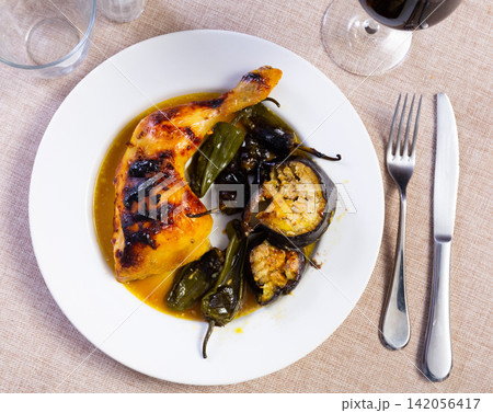 Chicken thigh with stewed eggplant on a ceramic plate cooked in cafe Chicken thigh with stewed eggplant on a ceramic plate cooked in cafe 142056417