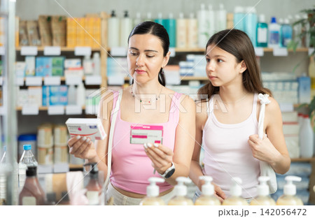 Mom and daughter customer choosing paracetamol in drugstore Mom and daughter customer choosing paracetamol in drugstore 142056472