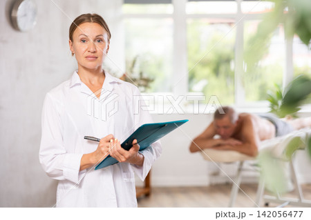 masseuse with folder at massage room masseuse with folder at massage room 142056477