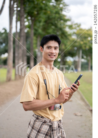 Asian Photographer Using Smartphone in Outdoor Park Asian Photographer Using Smartphone in Outdoor Park 142057286