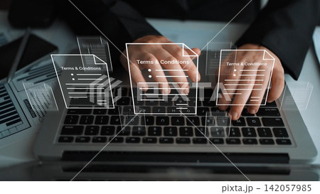 Modern Business Technology Concept with Hands Typing on Laptop Keyboard and Digital Representation of Terms and Conditions Documents Overlaying Screen Gluon Modern Business Technology Concept with Hands Typing on Laptop Keyboard and Digital Representation of Terms and Conditions Documents Overlaying Screen Gluon 142057985
