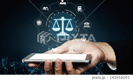 A hand holds a smartphone displaying scales of justice and legal icons, representing the intersection of law, technology, and modern communication in today society. Sigmoid A hand holds a smartphone displaying scales of justice and legal icons, representing the intersection of law, technology, and modern communication in today society. Sigmoid 142058201