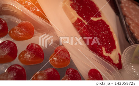 Vacuum skin packaging technology preserving fresh beef steak and heart shaped gummy candy under transparent plastic film, premium food packaging for retail display, food safety and extended shelf life Vacuum skin packaging technology preserving fresh beef steak and heart shaped gummy candy under transparent plastic film, premium food packaging for retail display, food safety and extended shelf life 142059728