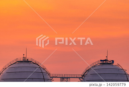 Spherical LNG storage tanks at a natural gas terminal beneath sunset sky, modern petroleum refinery infrastructure. Global energy storage, fuel supply and industrial engineering. Energy security. Spherical LNG storage tanks at a natural gas terminal beneath sunset sky, modern petroleum refinery infrastructure. Global energy storage, fuel supply and industrial engineering. Energy security. 142059779