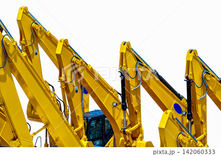 Rows of yellow hydraulic excavators with powerful boom arms parked at heavy equipment yard. Construction machinery, civil engineering, industrial technology and infrastructure development. 142060333
