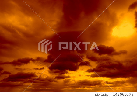 Beautiful sunset sky. Golden sunset sky with beautiful pattern of clouds. Orange, yellow, and dark clouds in the evening. Freedom and calm background. Beauty in nature. Powerful and spiritual scene. 142060375