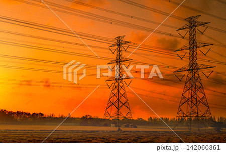 High voltage electric pylon and electrical wire with sunset sky. Electricity poles. Power and energy concept. High voltage grid tower with wire cable. Beautiful red-orange sunset sky. Infrastructure. High voltage electric pylon and electrical wire with sunset sky. Electricity poles. Power and energy concept. High voltage grid tower with wire cable. Beautiful red-orange sunset sky. Infrastructure. 142060861