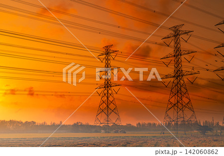 High voltage electric pylon and electrical wire with sunset sky. Electricity poles. Power and energy concept. High voltage grid tower with wire cable. Beautiful red-orange sunset sky. Infrastructure. High voltage electric pylon and electrical wire with sunset sky. Electricity poles. Power and energy concept. High voltage grid tower with wire cable. Beautiful red-orange sunset sky. Infrastructure. 142060862