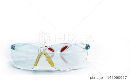 Clear protective safety goggles for industrial workers, laboratory technicians and construction professionals, isolated on white background for workplace security, compliance and personal protection. Clear protective safety goggles for industrial workers, laboratory technicians and construction professionals, isolated on white background for workplace security, compliance and personal protection. 142060937