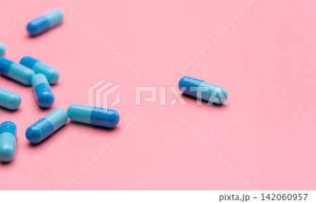 Blue capsule pill on pink background for online pharmacy, pharmaceutical industry, women healthcare, health insurance, drug research, breast cancer treatment, and medical innovation. Prescription drug Blue capsule pill on pink background for online pharmacy, pharmaceutical industry, women healthcare, health insurance, drug research, breast cancer treatment, and medical innovation. Prescription drug 142060957