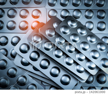 Pile of silver aluminum blister packs for pharmaceutical tablets, medicine packaging background. Drug recall, product withdrawal, pharmacy manufacturing, healthcare regulation and quality control. Pile of silver aluminum blister packs for pharmaceutical tablets, medicine packaging background. Drug recall, product withdrawal, pharmacy manufacturing, healthcare regulation and quality control. 142061000
