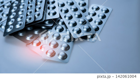 Pile of silver aluminum blister packs for pharmaceutical tablets, medicine packaging background. Drug recall, product withdrawal, pharmacy manufacturing, healthcare regulation and quality control. Pile of silver aluminum blister packs for pharmaceutical tablets, medicine packaging background. Drug recall, product withdrawal, pharmacy manufacturing, healthcare regulation and quality control. 142061004