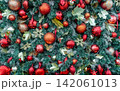 Close up of richly decorated Christmas tree with red baubles, glitter ornaments, evergreen branches and festive decorations creating vibrant holiday background for Christmas and New Year celebrations. 142061013