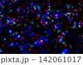 Abstract colorful Christmas bokeh lights with glowing red, blue and green illumination. Festive holiday background, perfect for seasonal greeting cards, winter celebrations and New Year designs. 142061017