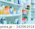 Abstract blurred pharmacy shelves displaying medicine packaging and pharmaceutical products. Healthcare services, prescription medication, drug retail and medical business concepts. Medical industry. 142061018