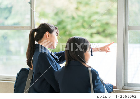 学校の廊下で会話する制服姿の中学生の女子生徒 学校の廊下で会話する制服姿の中学生の女子生徒 142061662