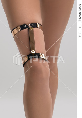 Leg adorned with gold and black fashionable jewelry Leg adorned with gold and black fashionable jewelry 142061859