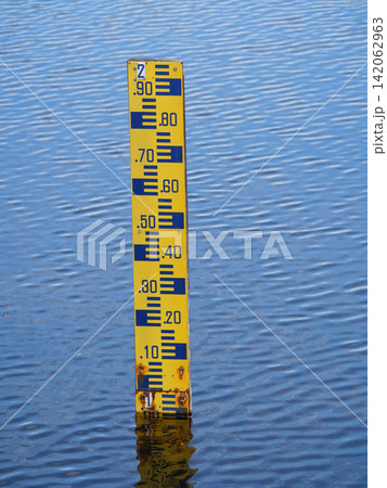Yellow water level gauge or staff Gauge with alphabet number with reflection on the blue water surface Yellow water level gauge or staff Gauge with alphabet number with reflection on the blue water surface 142062963