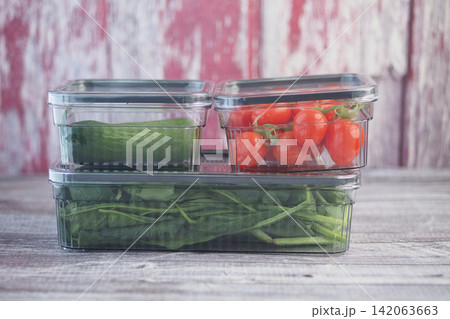 Fresh vegetables in clear containers on a wooden table Fresh vegetables in clear containers on a wooden table 142063663