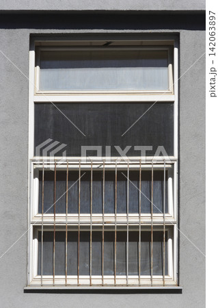 White window with safety bars on gray wall White window with safety bars on gray wall 142063897