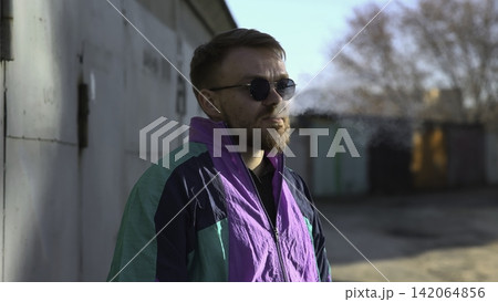 Pensive Individual By Aged Doors. Reflective Man Pauses With Cigarette Beside Old Doorways. Media Pensive Individual By Aged Doors. Reflective Man Pauses With Cigarette Beside Old Doorways. Media 142064856