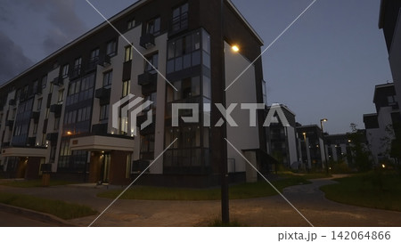 Modern apartment complex at dusk with streetlights Modern apartment complex at dusk with streetlights 142064866
