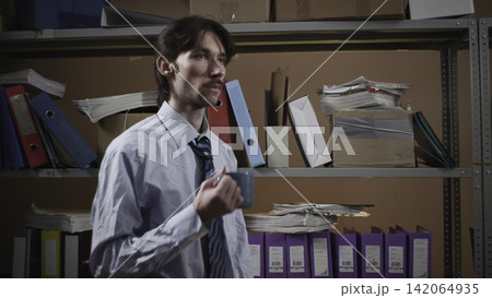 Office clerk presenting in a storage archive Office clerk presenting in a storage archive 142064935