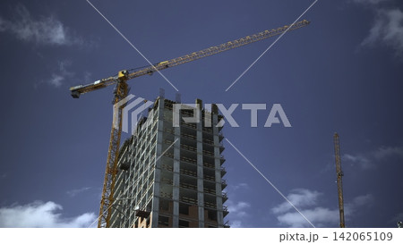 Tower crane above high-rise building under construction Tower crane above high-rise building under construction 142065109